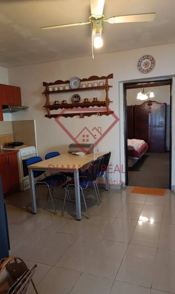 Na predaj RD na bývanie alebo investičná príležitosť Horné Saliby - Jedálenský kút a kuchyňa v rodinnom dome s poličkou a stropným ventilátorom.