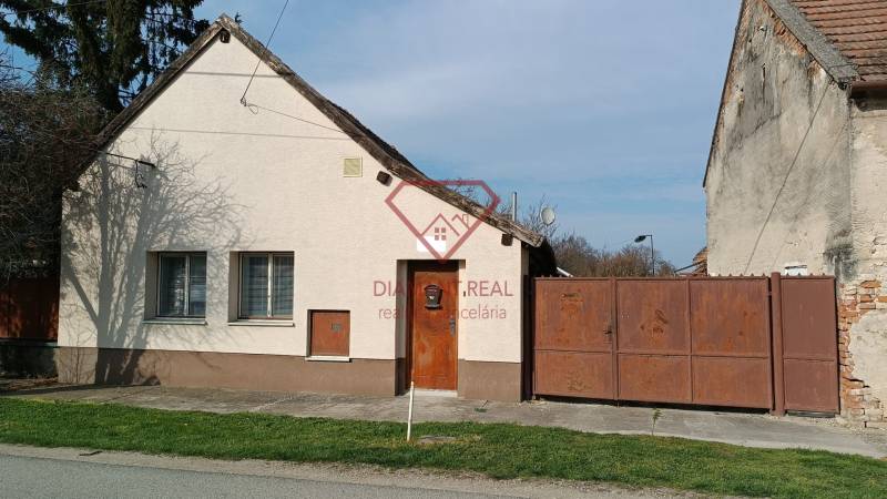 Na predaj RD na bývanie alebo investičná príležitosť Horné Saliby - Rodinný dom na Salibskej ulici v Horných Salibách s jednoduchou fasádou a kovovou bránou.