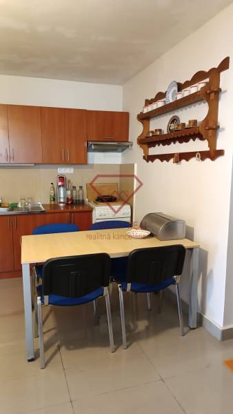 Na predaj RD na bývanie alebo investičná príležitosť Horné Saliby - Jedáleň v rodinnom dome s kuchynskou linkou, stolom a policou na stene.