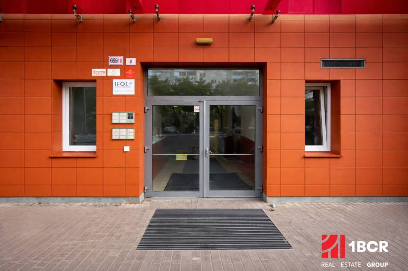 INVESTIČNÉ BÝVANIE V TOP LOKALITE: 2-IZBOVÝ BYT, JÉGÉHO UL, BRATISLAVA - Vchod do budovy na Jégého ulici v Bratislave - Ružinove, s červenými obkladmi.