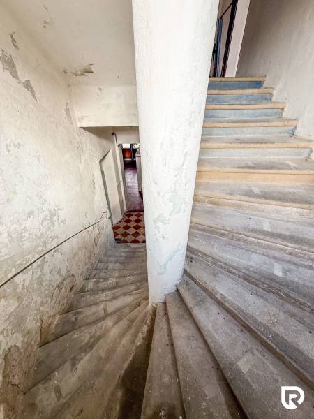 Rodinný dom (bytovka) s pozemkom 554m2, Bobotská Lehota - Schodisko vedúce do interiéru rodinného domu s opotrebovanou omietkou na stenách.