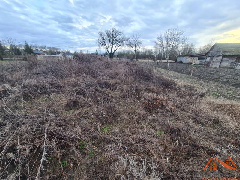 Na predaj pozemok Martovce ! - Pozemky - bývanie v Martovciach, neupravovaný terén, staršie drevené stavby, stromy, oblaky na oblohe.