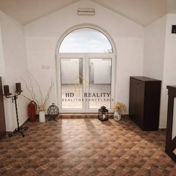 Prenájom gastro priestoru v centre Krupiny - Interiérové gastro priestory s ozdobnými prvkami, kachľovou podlahou a veľkým oblúkovým oknom.