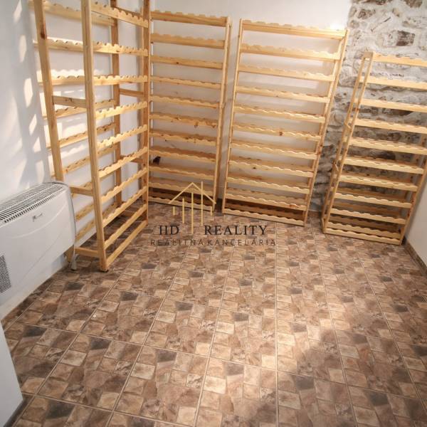 Prenájom gastro priestoru v centre Krupiny - Regály z dreva, kamenná stena, podlaha s geometrickým vzorom v gastro priestoroch.