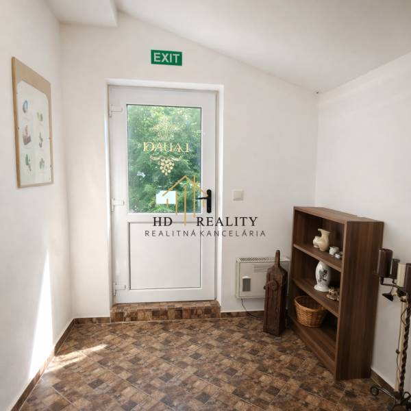 Prenájom gastro priestoru v centre Krupiny - Interiér gastro priestorov s presklenými dvermi, policou a podlahou s dreveným dekorom.