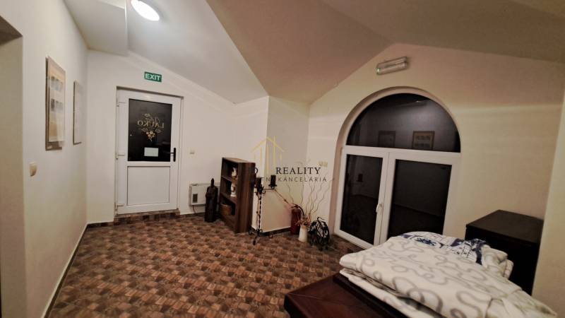 Prenájom gastro priestoru v centre Krupiny - Interiér Gastro priestorov s podlahou s dreveným dekorom, dverami a dekoráciami.