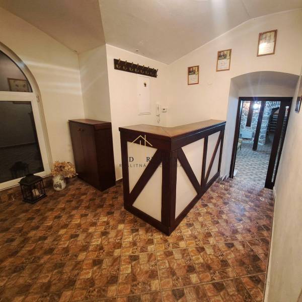 Prenájom gastro priestoru v centre Krupiny - Interiér gastro priestoru s pultom, podlahou s dreveným dekorom a vešiakom.