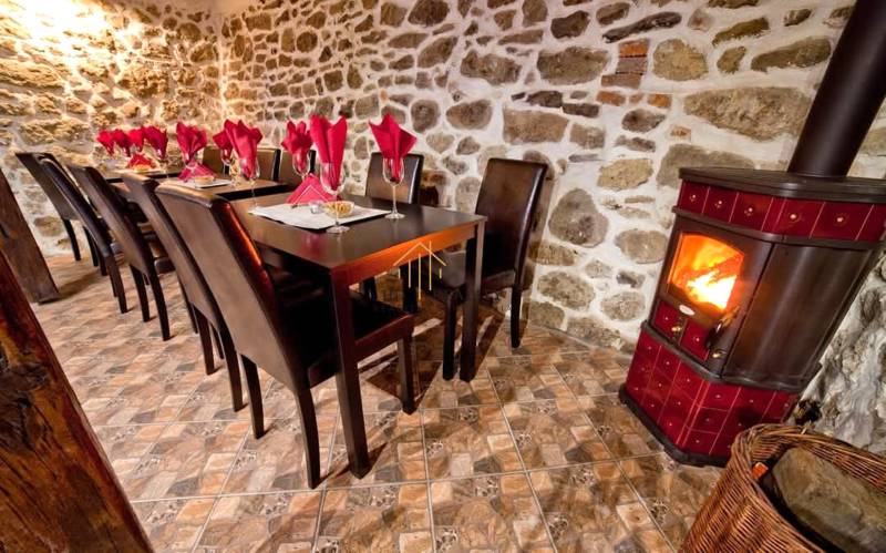 Prenájom gastro priestoru v centre Krupiny - Rustikálne gastro priestory s krbom, kamennou stenou a stolmi so servítkami.