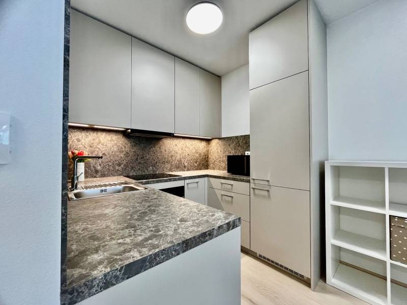 PRENÁJOM NOVOSTAVBA 2 izb.byt, BALKÓN, PARKOVACIE MIESTO, BIELY KOSTOL - Kuchyňa v 2-izbovom byte s kameňovou pracovnou doskou a bielymi skrinkami.