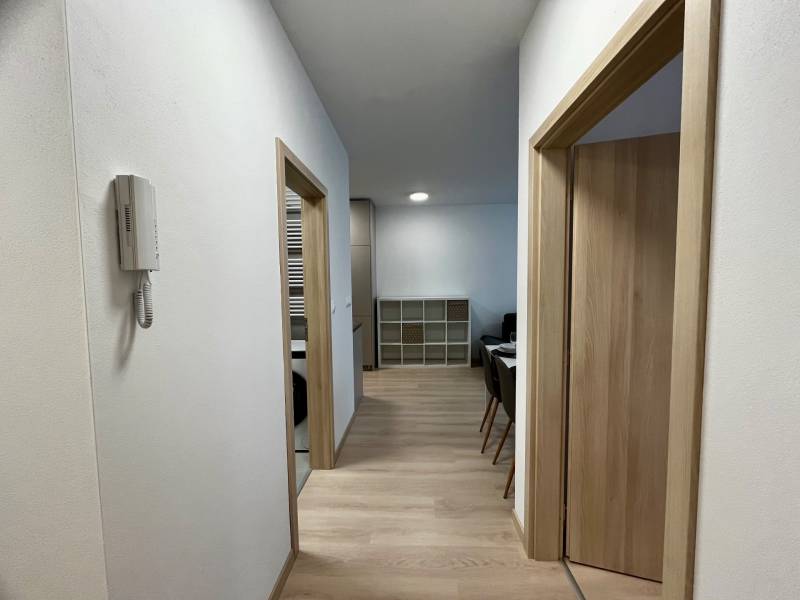 PRENÁJOM NOVOSTAVBA 2 izb.byt, BALKÓN, PARKOVACIE MIESTO, BIELY KOSTOL - Chodba v 2-izbovom byte s podlahou s dreveným dekorom a jednoduchým interiérom.