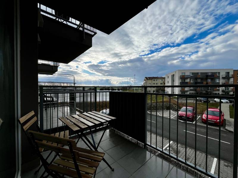 PRENÁJOM NOVOSTAVBA 2 izb.byt, BALKÓN, PARKOVACIE MIESTO, BIELY KOSTOL - Balkón 2-izbového bytu v Bielom Kostole s výhľadom na parkovisko a oblohu.