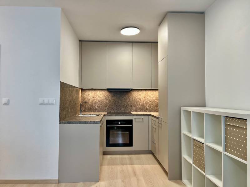 PRENÁJOM NOVOSTAVBA 2 izb.byt, BALKÓN, PARKOVACIE MIESTO, BIELY KOSTOL - Kuchyňa v 2-izbovom byte s podlahou s dreveným dekorom a úložnými policami.