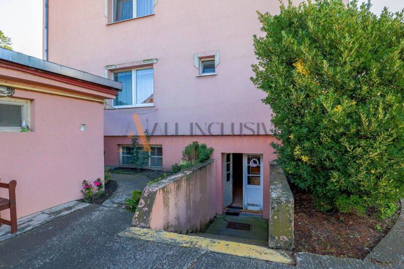 NA PREDAJ 7 IZBOVÝ RODINNÝ DOM, DUNAJSKÁ STREDA - Rodinný dom na Malotejedskej ulici v Dunajskej Strede s ružovou fasádou a zeleňou.