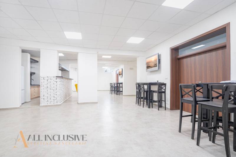 NA PRENÁJOM OBCHODNÝ PRIESTOR-KANCELÁRIA ,DUN. STREDA - Svetlá kancelária na ulici Jilemnického s barovým pultom, obrázkami a dreveným nábytkom.