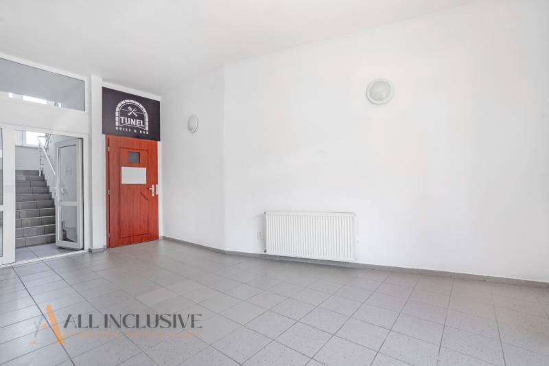 NA PRENÁJOM OBCHODNÝ PRIESTOR-KANCELÁRIA ,DUN. STREDA - Prázdny priestor na ulici Jilemnického, biele steny, dvere do kancelárie a schody.