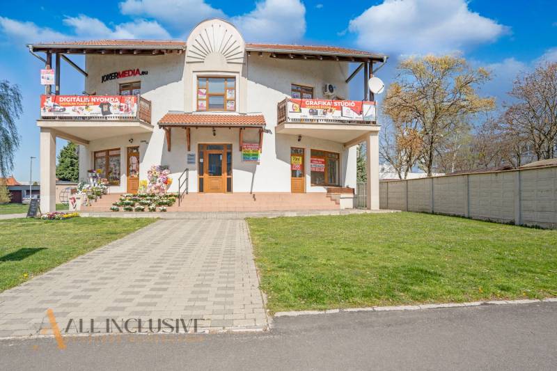 NA PRENÁJOM OBCHODNÝ PRIESTOR-KANCELÁRIA ,DUN. STREDA - Na ulici Jilemnického budova s reklamou a kvetinovou dekoráciou pred kanceláriou.