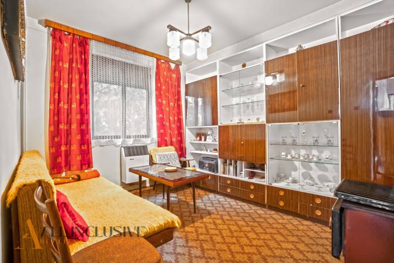 NA PREDAJ 2-IZBOVÝ RODINNÝ DOM S PODKROVÍM, BODÍKY - Obývačka v rodinnom dome so sedačkou, sekretárom a závesmi s červeným vzorom.