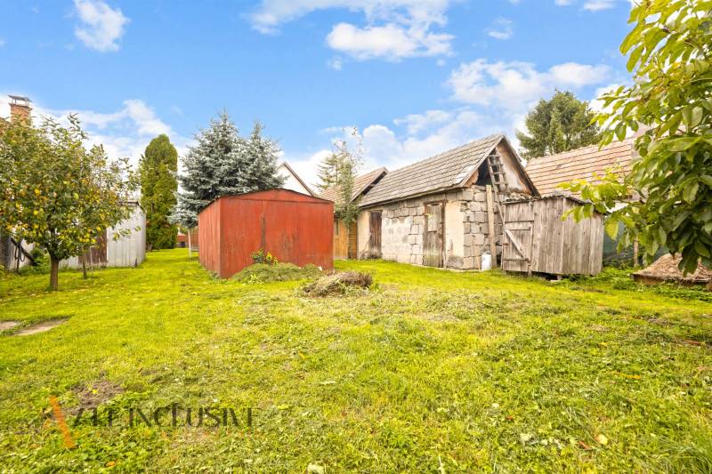 NA PREDAJ 2-IZBOVÝ RODINNÝ DOM S PODKROVÍM, BODÍKY - Záhrada v Bodíkoch s drevenými a murovanými prístreškami pri rodinnom dome na slnečnom dni.