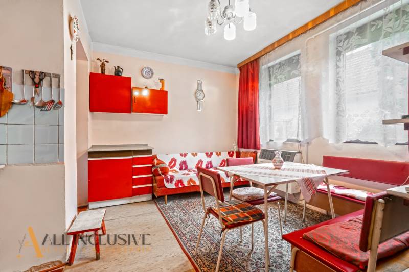 NA PREDAJ 2-IZBOVÝ RODINNÝ DOM S PODKROVÍM, BODÍKY - Interiér rodinného domu s červenou kuchynskou linkou a textilným dekorom na stene.