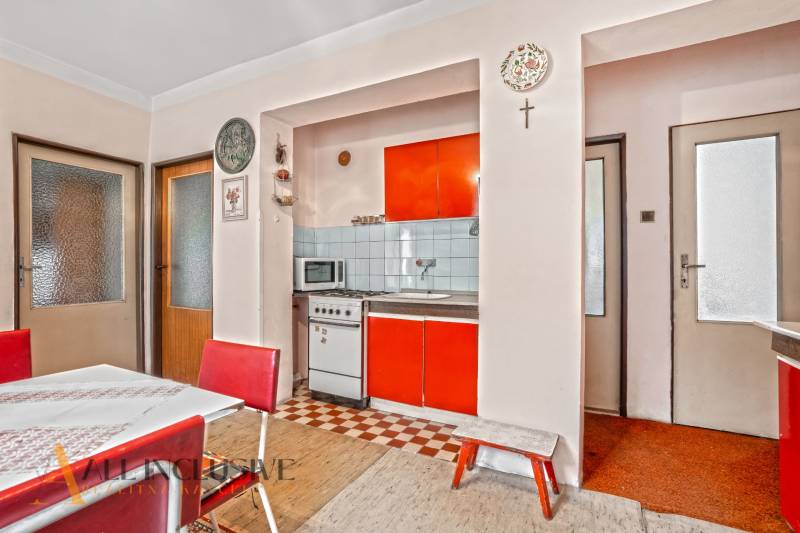 NA PREDAJ 2-IZBOVÝ RODINNÝ DOM S PODKROVÍM, BODÍKY - Interiér rodinného domu s výraznou oranžovou kuchyňou a retro nábytkom.