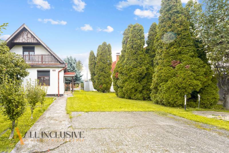 NA PREDAJ 2-IZBOVÝ RODINNÝ DOM S PODKROVÍM, BODÍKY - Rodinný dom v Bodíkoch s upravenou záhradou a chodníkom medzi stromami.