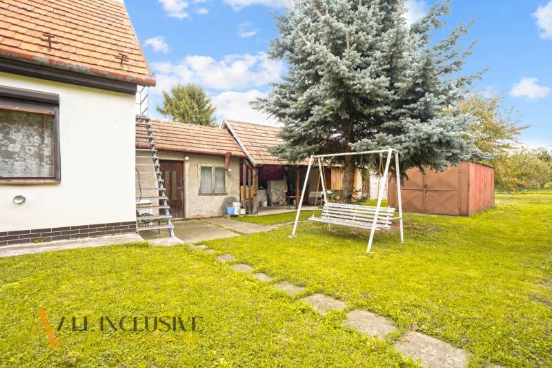 NA PREDAJ 2-IZBOVÝ RODINNÝ DOM S PODKROVÍM, BODÍKY - Rodinný dom v Bodíkoch s dvorom, hojdačkou a ihličnatým stromom.