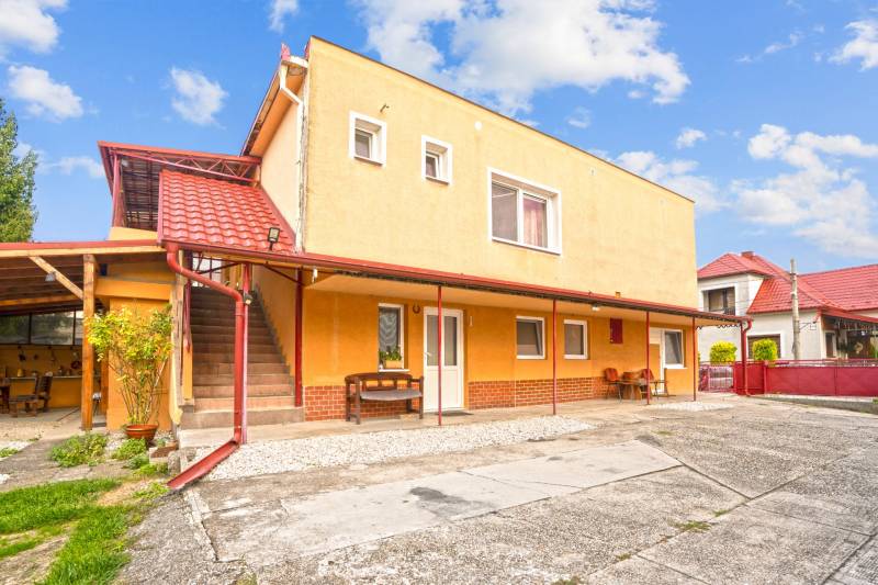 NA PREDAJ VÝNIMOČNÝ RODINNÝ DOM VO VEĽKOM MEDERI - Rodinný dom vo Veľkom Mederi s červenou strechou a vonkajšími schodmi.