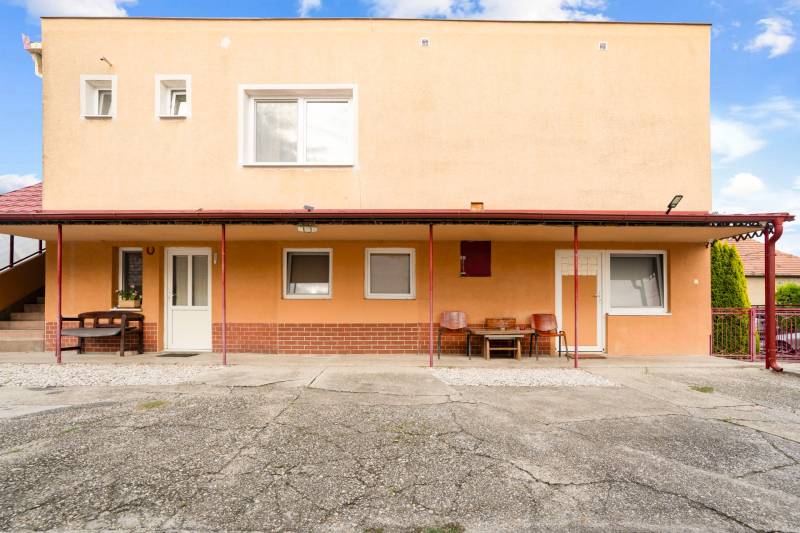 NA PREDAJ VÝNIMOČNÝ RODINNÝ DOM VO VEĽKOM MEDERI - Exteriér rodinného domu vo Veľkom Mederi s terasou a stoličkami.