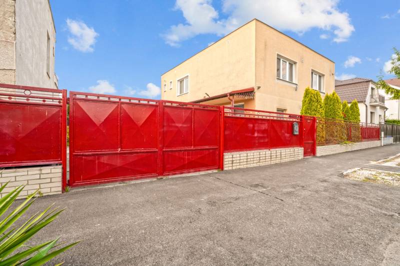 NA PREDAJ VÝNIMOČNÝ RODINNÝ DOM VO VEĽKOM MEDERI - Rodinný dom vo Veľkom Mederi, výrazná červená brána, betónová príjazdová cesta.