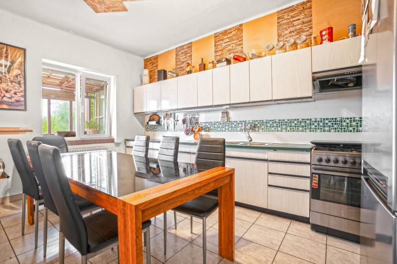 NA PREDAJ VÝNIMOČNÝ RODINNÝ DOM VO VEĽKOM MEDERI - Kuchynský priestor s jedálenským stolom a šiestimi stoličkami v rodinnom dome.