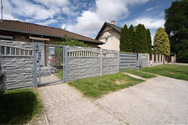 NA PREDAJ 3 IZBOVÝ RODINNÝ DOM, KĽÚČIAROVÉ KRAČANY - Rodinný dom v Kráľovičových Kračanoch, Dunajská Streda, s kamenným plotom a bránou.