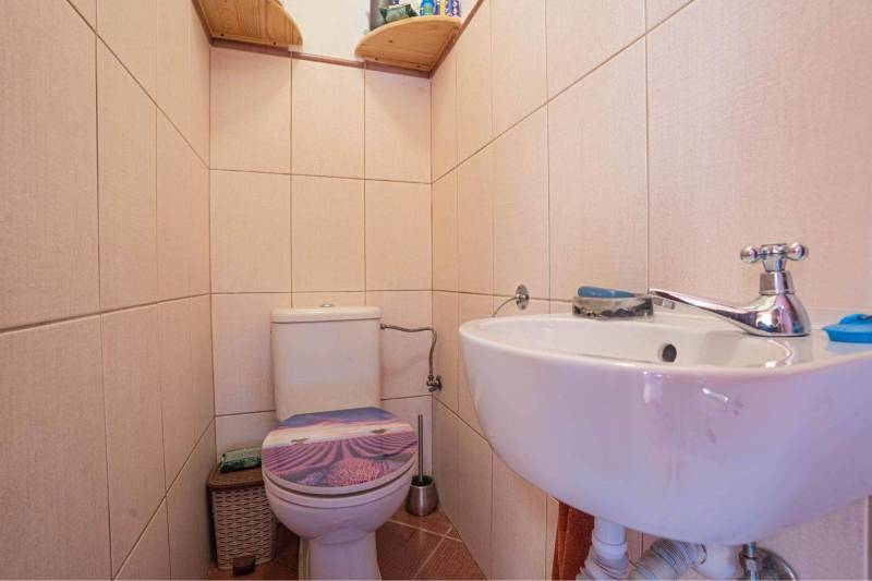 NA PREDAJ 3 IZBOVÝ RODINNÝ DOM, KĽÚČIAROVÉ KRAČANY - Toaleta s umývadlom v rodinnom dome, obložená svetlými keramickými kachličkami.