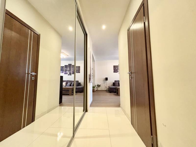 Štýlový, zariadený 2- izbový byt s balkónom pri stanici!!! - Chodba v 2-izbovom byte s dlažbou, zrkadlom a pohľadom do obývacej izby.