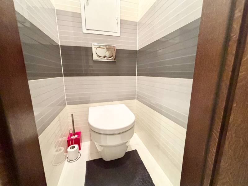 Štýlový, zariadený 2- izbový byt s balkónom pri stanici!!! - Toaleta v 2-izbovom byte s bielymi a šedými dlaždicami na stenách.