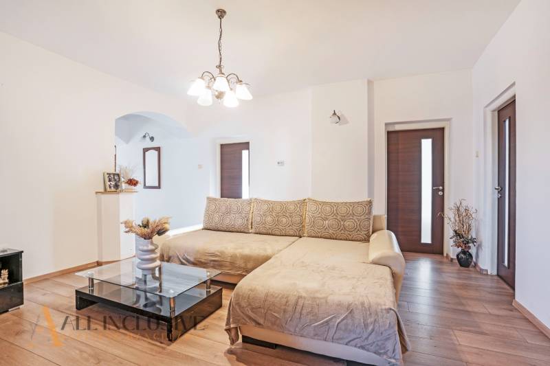 ZNÍŽENÁ CENA | NA PREDAJ DVOJGENERAČNÝ RODINNÝ DOM, AMADE KRAČANY - Svetlá obývacia izba s pohodlnou sedačkou a konferenčným stolíkom na ulici Amade Kračany.