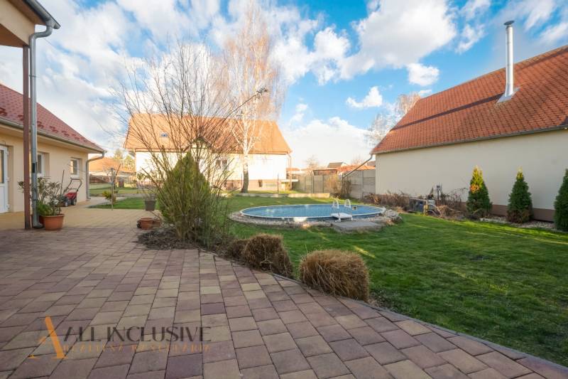 ZNÍŽENÁ CENA | NA PREDAJ DVOJGENERAČNÝ RODINNÝ DOM, AMADE KRAČANY - Záhrada s bazénom, terasou, trávnikom a dom na ulici Amade Kračany.
