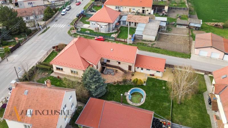 ZNÍŽENÁ CENA | NA PREDAJ DVOJGENERAČNÝ RODINNÝ DOM, AMADE KRAČANY - Letecký pohľad na rodinné domy na ulici Amade Kračany s bazénom a záhradou.