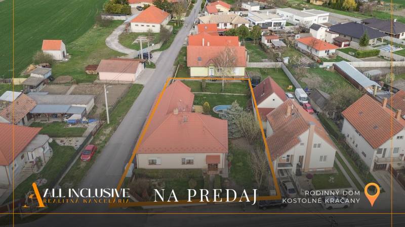ZNÍŽENÁ CENA | NA PREDAJ DVOJGENERAČNÝ RODINNÝ DOM, AMADE KRAČANY - Letecký pohľad na ulicu Amade Kračany s rodinným domom obklopeným záhradou a bazénom.