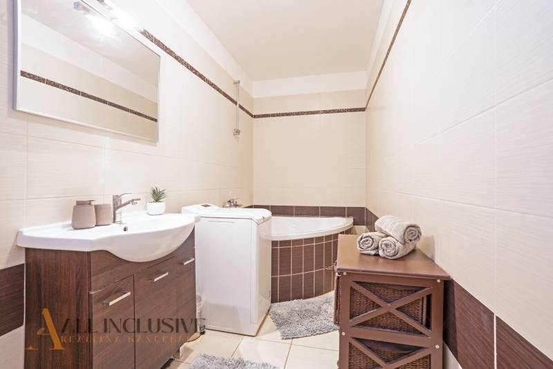 ZNÍŽENÁ CENA | NA PREDAJ DVOJGENERAČNÝ RODINNÝ DOM, AMADE KRAČANY - Elegantná kúpeľňa s vaňou, umývadlom a práčkou, na ulici Amade Kračany. Rodinný dom.