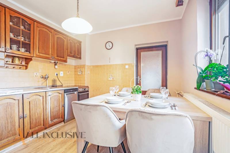 ZNÍŽENÁ CENA | NA PREDAJ DVOJGENERAČNÝ RODINNÝ DOM, AMADE KRAČANY - Kuchyňa s drevenými skrinkami a stolom v rodinnom dome na ulici Amade Kračany.