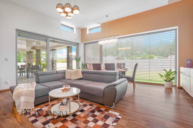 NA PREDAJ NADŠTANDARDNÁ 4-IZB. NOVOSTAVBA, DUN. KLÁTOV - Obývačka v Rodinnom dome s veľkým rohovým gaučom, jedálenským stolom a presklením.