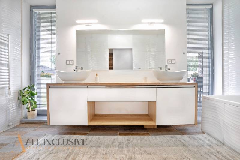 NA PREDAJ NADŠTANDARDNÁ 4-IZB. NOVOSTAVBA, DUN. KLÁTOV - Kúpeľňa v rodinnom dome s dvoma umývadlami, veľkým zrkadlom a dekoratívnou rastlinou.