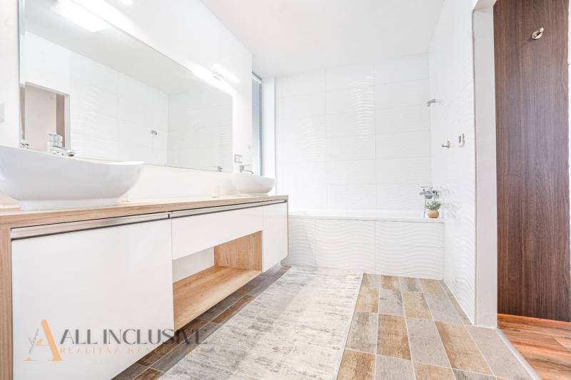 NA PREDAJ NADŠTANDARDNÁ 4-IZB. NOVOSTAVBA, DUN. KLÁTOV - Kúpeľňa v rodinnom dome s umývadlami, bielymi stenami a drevenou podlahou.