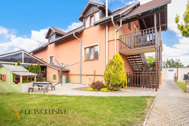 NA PREDAJ PENZIÓN VO VEĽKOM MEDERI – SUNGARDEN - Exteriér budovy s drevenými terasami, záhradou a ihriskom vo Veľkom Mederi, hotely a penzióny.