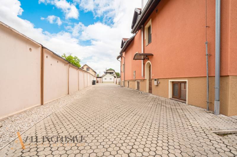 NA PREDAJ PENZIÓN VO VEĽKOM MEDERI – SUNGARDEN - Plochá cesta lemovaná oranžovou budovou v priestoroch hotelov a penziónov Veľkého Medera.