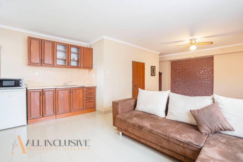 NA PREDAJ PENZIÓN VO VEĽKOM MEDERI – SUNGARDEN - Interiér kuchynky v hoteloch a penziónoch s pohovkou a drevenou linkou.