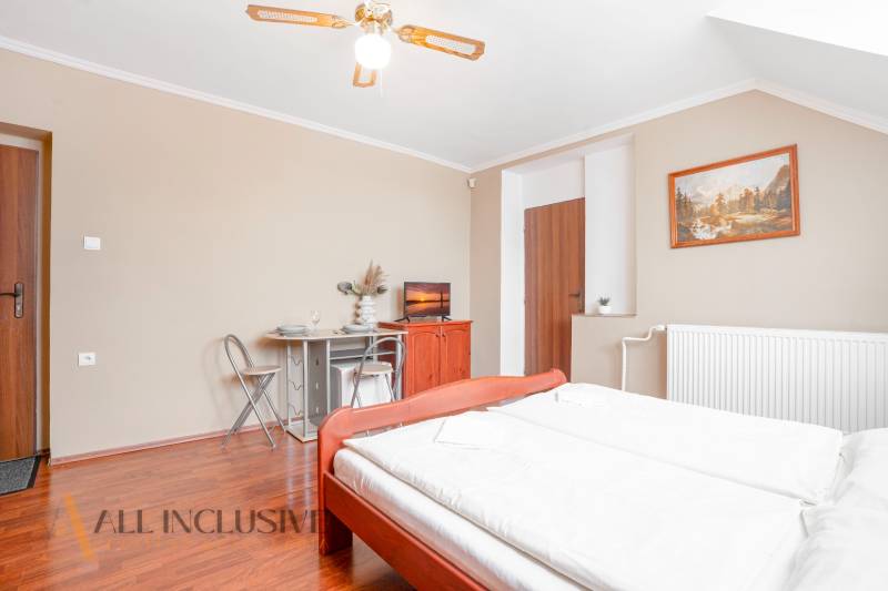 NA PREDAJ PENZIÓN VO VEĽKOM MEDERI – SUNGARDEN - Svetlá izba v hoteli s manželskou posteľou, dekoráciami a jedálenským kútom.