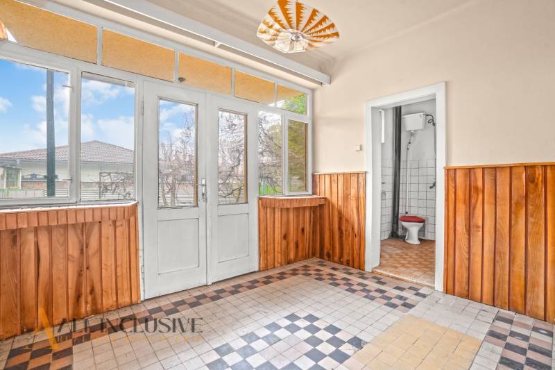 REZERVOVANÉ 4-IZBOVÝ RODINNÝ DOM, TOPOĽNÍKY - Interiér rodinného domu s dreveným obkladom a svetlou dlažbou, výhľad na záhradu.