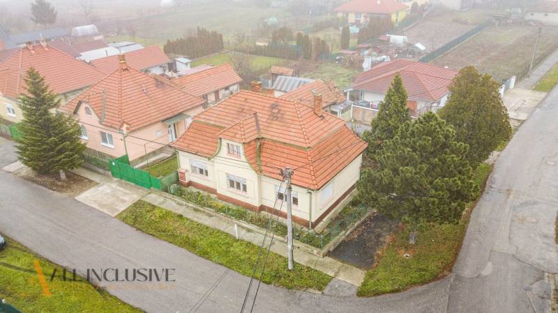 REZERVOVANÉ 4-IZBOVÝ RODINNÝ DOM, TOPOĽNÍKY - Pohľad zhora na rodinný dom v Topoľníkoch so šikmou strechou a záhradou.