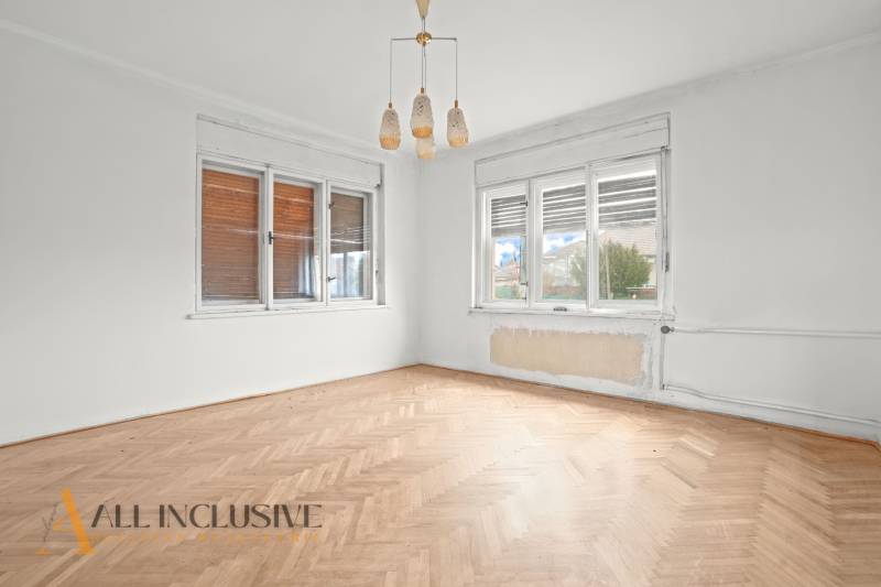 REZERVOVANÉ 4-IZBOVÝ RODINNÝ DOM, TOPOĽNÍKY - Prázdna izba v rodinnom dome s podlahou s dreveným dekorom a veľkými oknami.